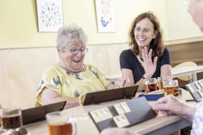 Dame speelt Rumikub in een buurthuis