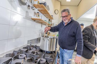 Man is aan het koken in een huis van de wijk