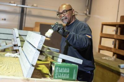 Medewerker van Goes verft een bankje