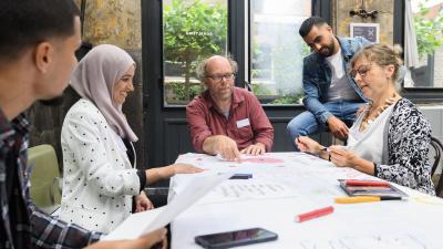 Overleg van een team van medewerkers van Incluzio Leiden