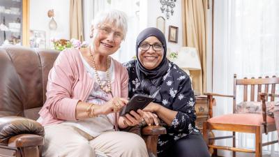 Vrouw helpt senioren dame met een ipad