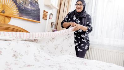 Medewerker Sfia maakt het bed op bij een client