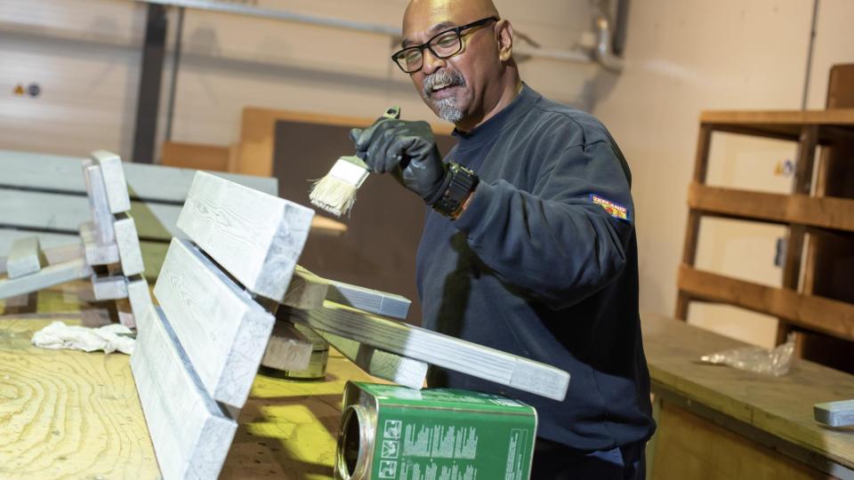 Medewerker van Goes verft een bankje